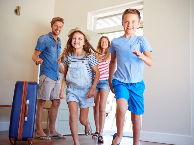 family-arriving-at-summer-vacation-rental-2021-08-26-16-14-21-utc
